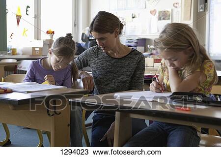Teacher teaching to girls in classroom View Large Photo Image Stock Image - Teacher teaching to girls in classroom. Fotosearch