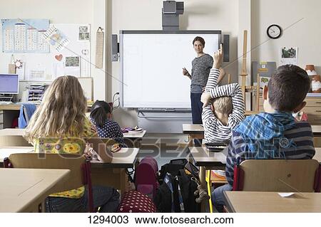 Teacher teaching to students in classroom View Large Photo Image Stock Image - Teacher teaching to students in classroom. Fotosearch