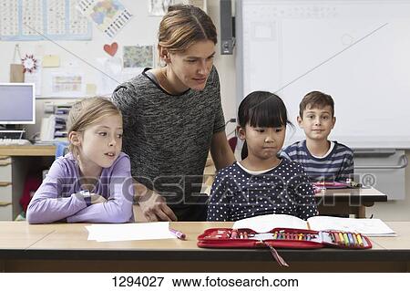Teacher teaching to students in classroom View Large Photo Image Stock Photo - Teacher teaching to students in classroom. Fotosearch