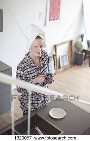 Stock Photo - Woman holding coffee cup, portrait. Fotosearch