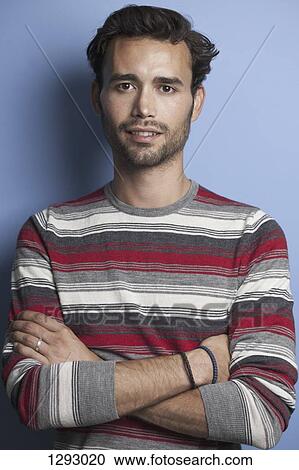 Stock Image - Young adult man looking at camera, close-up. Fotosearch