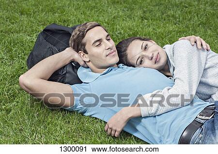 Stock Image - Young couple lying on grass. Fotosearch