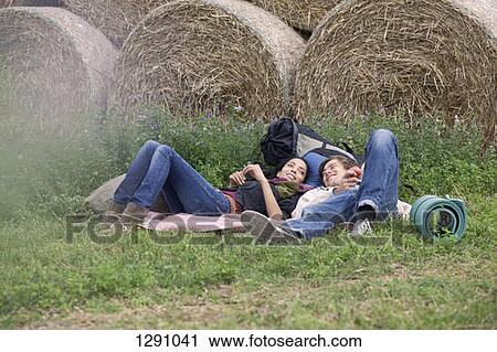 Young couple relaxing in field View Large Photo Image Stock Image - Young couple relaxing in field. Fotosearch