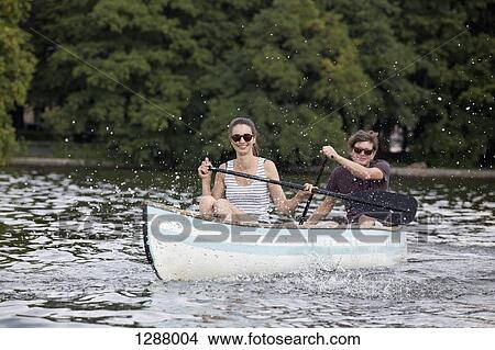 Young couple riding paddle boat on lake View Large Photo Image Picture - Young couple riding paddle boat on lake. Fotosearch