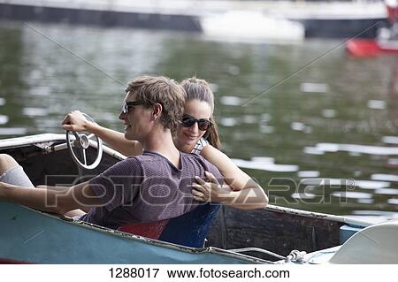 Young couple riding paddle boat on lake View Large Photo Image Stock Photo - Young couple riding paddle boat on lake. Fotosearch