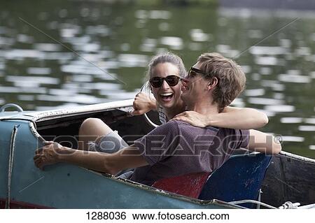 Young couple riding paddle boat, laughing View Large Photo Image Stock Photograph - Young couple riding paddle boat, laughing. Fotosearch