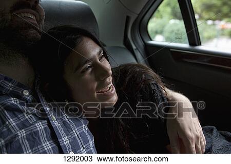 Stock Image - Young couple sitting in car. Fotosearch