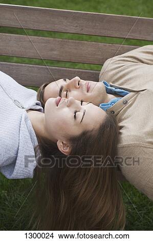 Picture - Young couple sleeping on bench. Fotosearch