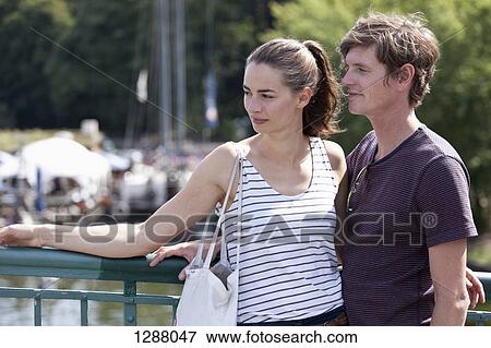 Stock Photo - Young couple standing on bridge. Fotosearch