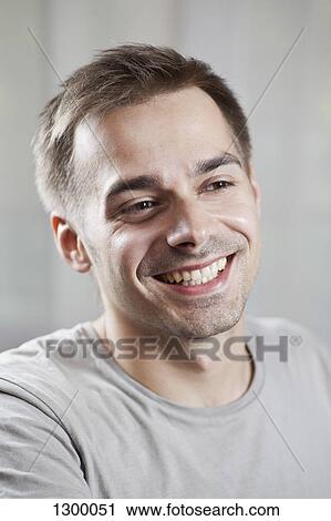 Young man looking away and smiling, close-up View Large Photo Image Stock Image - Young man looking away and smiling, close-up. Fotosearch