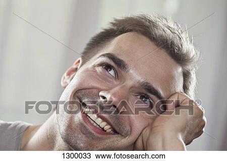 Young man looking up and smiling, close-up View Large Photo Image Stock Image - Young man looking up and smiling, close-up. Fotosearch