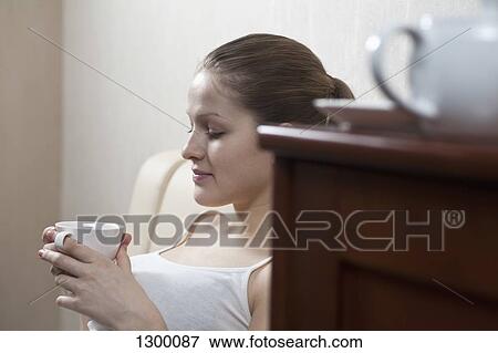 Stock Photo - Young woman holding tea cup. Fotosearch