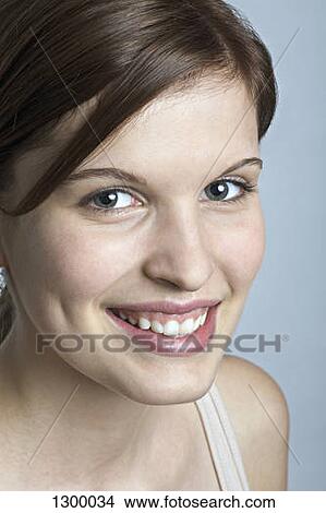 Picture - Young woman looking at camera, close-up. Fotosearch