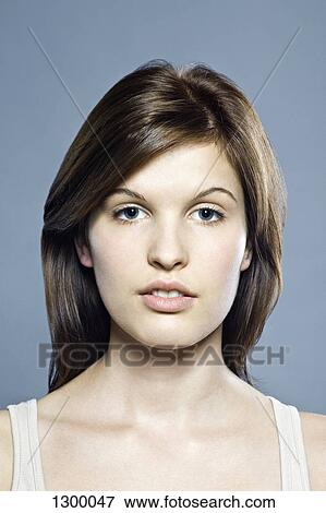 Stock Photo - Young woman looking at camera, close-up. Fotosearch