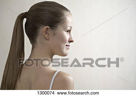 Picture - Young woman looking away, smiling. Fotosearch