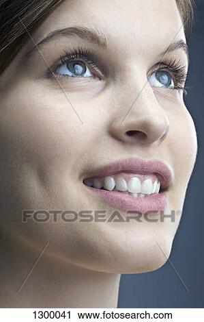 Young woman looking up and smiling, close-up View Large Photo Image Stock Image - Young woman looking up and smiling, close-up. Fotosearch