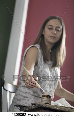 Young woman painting with paintbrush View Large Photo Image Stock Image - Young woman painting with paintbrush. Fotosearch