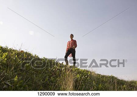 Young woman standing in park, low angle view View Large Photo Image Stock Photo - Young woman standing in park, low angle view. Fotosearch