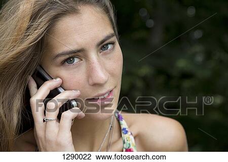 Young woman talking on mobile phone, close-up View Large Photo Image Stock Image - Young woman talking on mobile phone, close-up. Fotosearch