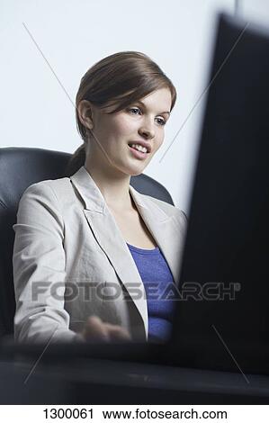 Young woman working at office View Large Photo Image Stock Image - Young woman working at office. Fotosearch