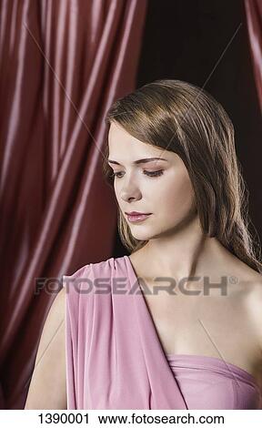Stock Image - Beautiful young woman in front of curtain. Fotosearch