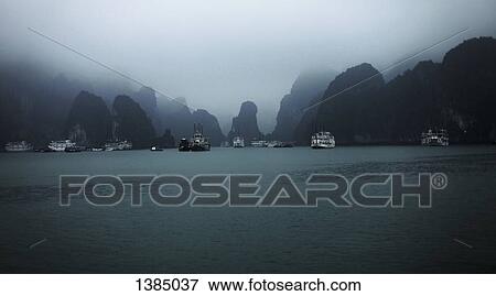 Stock Photo - "Boats at Halong bay against sky, Vietnam". Fotosearch