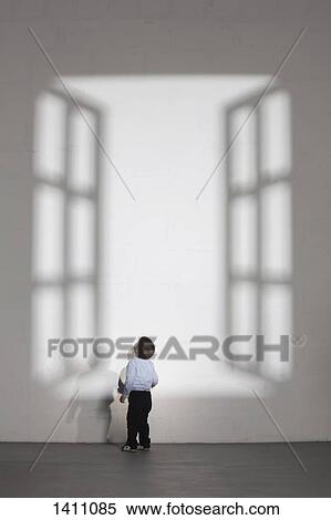 Boy looking at shadow of open window on white wall at home View Large Photo Image Stock Photography - Boy looking at shadow of open window on white wall at home. Fotosearch