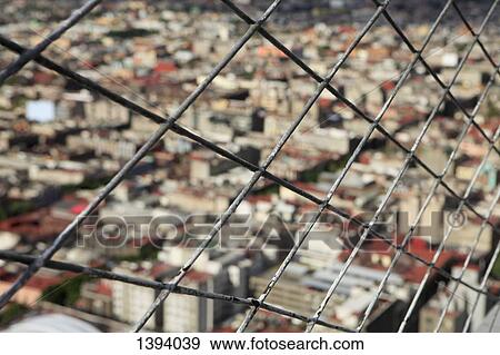 Stock Photo - Cityscape seen through chainlink fence. Fotosearch