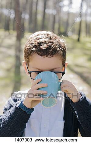 Close-up of boy drinking coffee in forest View Large Photo Image Stock Image - Close-up of boy drinking coffee in forest. Fotosearch