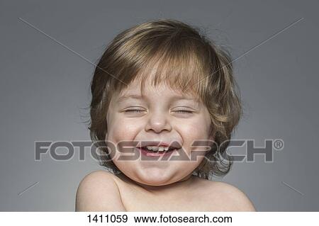 Close-up of cheerful boy with eyes closed over gray background View Large Photo Image Stock Photo - Close-up of cheerful boy with eyes closed over gray background. Fotosearch