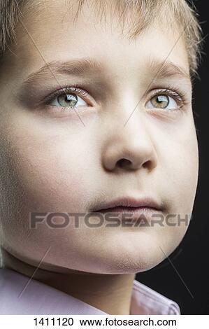 Close-up of thoughtful boy looking away against black background View Large Photo Image Stock Image - Close-up of thoughtful boy looking away against black background. Fotosearch