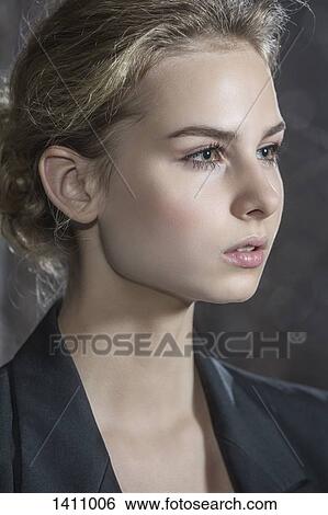 Stock Photograph - Close-up of thoughtful teenage girl against gray background. Fotosearch