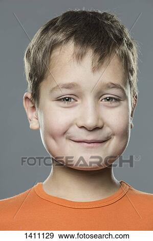 Stock Photo - Close-up portrait of boy against gray background. Fotosearch