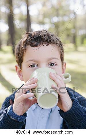 Picture - Close-up portrait of boy drinking coffee in forest. Fotosearch