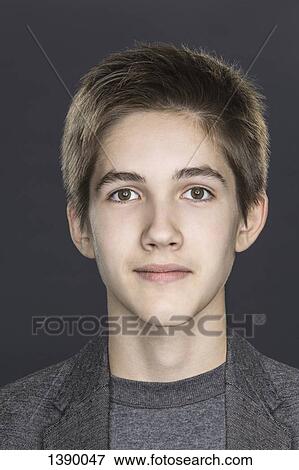 Stock Photo - Close-up portrait of confident teenage boy over gray background. Fotosearch