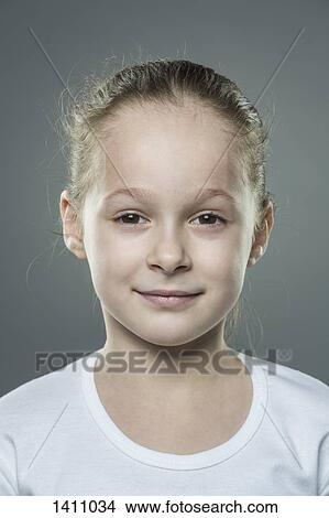 Picture - Close-up portrait of cute girl against gray background. Fotosearch