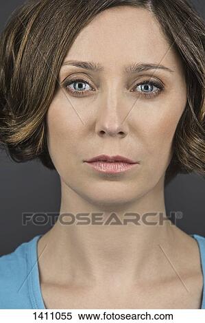 Close-up portrait of serious woman against gray background View Large Photo Image Stock Photography - Close-up portrait of serious woman against gray background. Fotosearch
