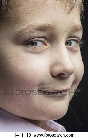 Close-up portrait of smiling boy against black background View Large Photo Image Stock Photo - Close-up portrait of smiling boy against black background. Fotosearch