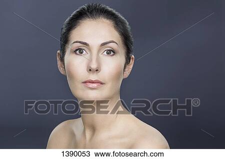 Stock Image - Close-up portrait of topless mature woman over gray background. Fotosearch