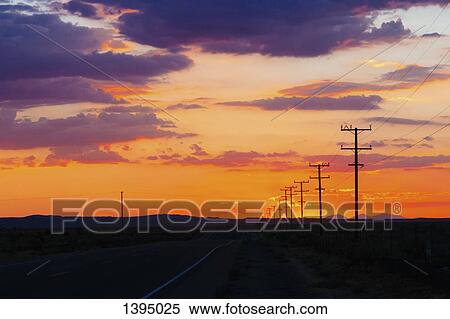 Country road and silhouette field against cloudy sky during sunset View Large Photo Image Stock Photography - Country road and silhouette field against cloudy sky during sunset. Fotosearch