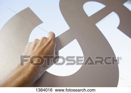 Cropped image of hand holding dollar sign against sky View Large Photo Image Stock Photograph - Cropped image of hand holding dollar sign against sky. Fotosearch