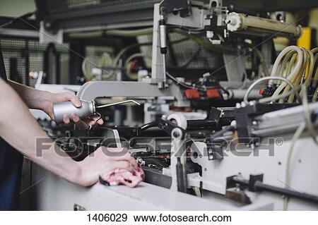 Cropped image of manual worker oiling machine in factory View Large Photo Image Stock Photo - Cropped image of manual worker oiling machine in factory. Fotosearch