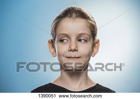 Stock Image - Cute girl looking sideways over blue background. Fotosearch