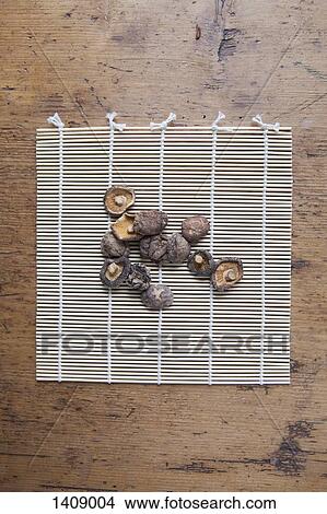 Picture - Directly above of dried white mushrooms on bamboo mat. Fotosearch