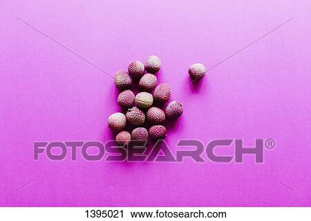 Stock Image - Directly above shot of lychees on pink background. Fotosearch