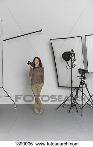 Full length of mature female photographer with camera in photo studio View Large Photo Image Stock Photograph - Full length of mature female photographer with camera in photo studio. Fotosearch
