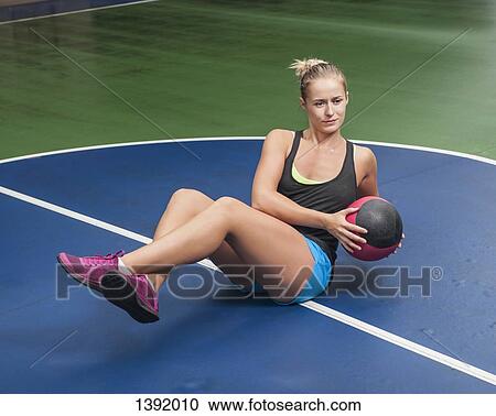 Full length of woman exercising with medicine ball in gym View Large Photo Image Stock Image - Full length of woman exercising with medicine ball in gym. Fotosearch