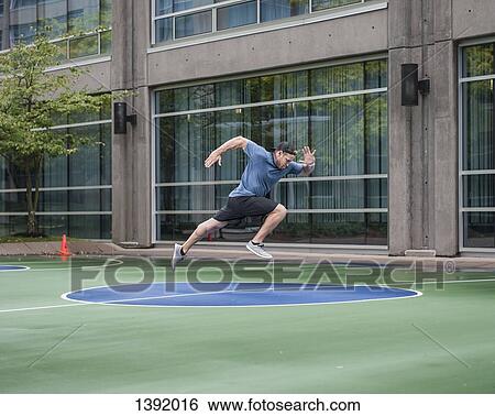 Full length of young man running against gym building View Large Photo Image Stock Photograph - Full length of young man running against gym building. Fotosearch