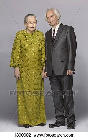Full length portrait of happy senior couple standing over gray background View Large Photo Image Stock Image - Full length portrait of happy senior couple standing over gray background. Fotosearch