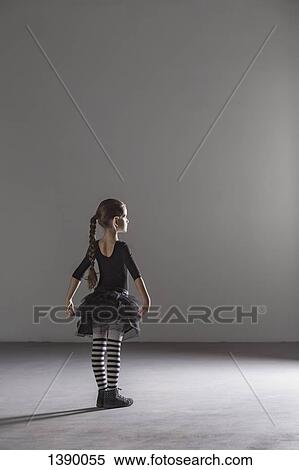 Stock Photography - Full length rear view of girl in ballet costume in studio. Fotosearch